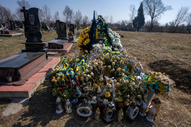 La tumba del soldado de 25 años Roman Pavlovich, que fue asesinado cerca de la ciudad sitiada de Mariupol en un cementerio en el pueblo de Hordinia, al oeste de Ucrania.