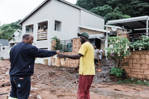 Un voluntario entrega dos hogazas de pan a un hombre en Durban el 12 de abril. 