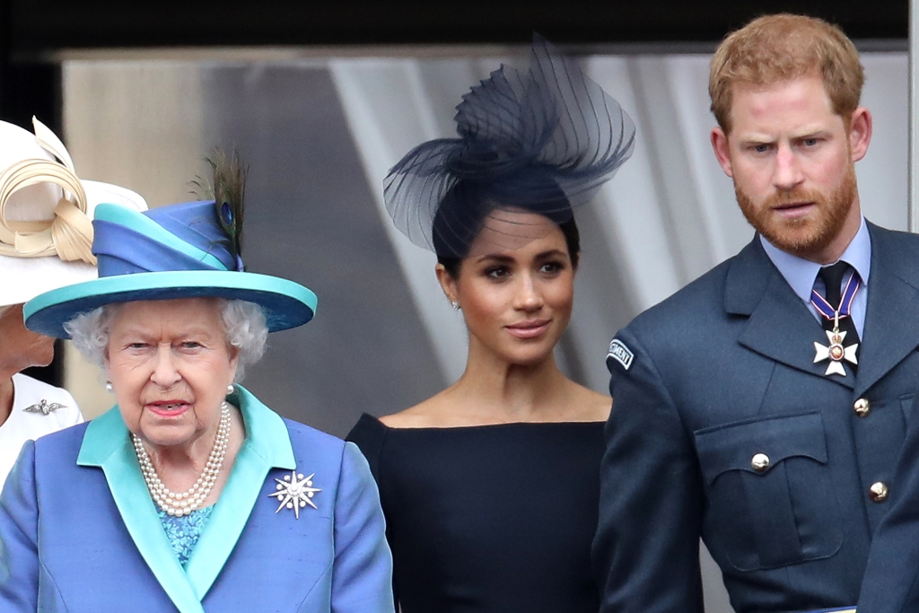 La reina Isabel II, el príncipe Harry, el duque de Sussex y Meghan, duquesa de Sussex en el balcón del Palacio de Buckingham mientras la familia real asiste a los eventos para celebrar el centenario de la RAF el 10 de julio de 2018 en Londres, Inglaterra. 