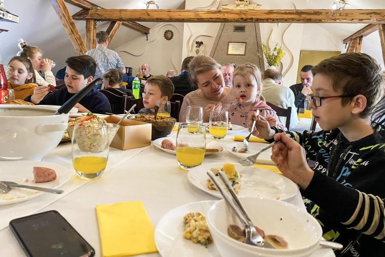 Tetiana Gorshunova ayuda a su hija a comer junto a otras familias de refugiados en un desayuno de Pascua en Varsovia.