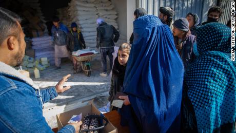 Una mujer afgana recibe su ración mensual de alimentos básicos para su familia en un punto de distribución del Programa Mundial de Alimentos en el distrito de Jay Rais, al oeste de Kabul.