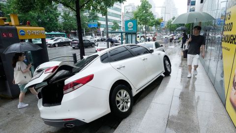 Un vehículo sufrió daños en la acera después de que se desvió en medio de fuertes lluvias en Seúl, Corea del Sur, el 9 de agosto.