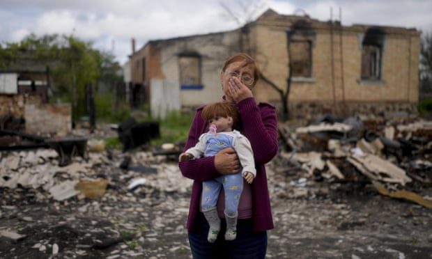 Nella Zelenska sostiene una muñeca que pertenece a su nieta frente a su casa destruida en Potashnya, en las afueras de Kyiv, Ucrania, en mayo.