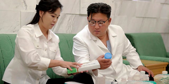 En esta foto proporcionada por el gobierno de Corea del Norte, el líder norcoreano Kim Jong Un y su esposa Ri Sol Ju preparan medicamentos en un lugar no revelado en Corea del Norte el miércoles 15 de junio de 2022 para enviarlos a la ciudad de Haeju, donde un ocurrió una enfermedad infecciosa.