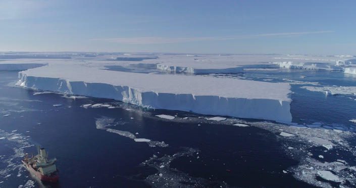 Un buque de investigación en el agua a lo largo del borde de la plataforma de hielo oriental de Thwaites en la Antártida.