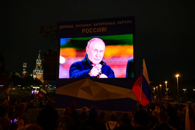 El presidente ruso, Vladimir Putin, aparece en una pantalla mientras se dirige a una multitud y un concierto que marca la anexión de cuatro regiones de Ucrania ocupadas por las fuerzas rusas: Lugansk, Donetsk, Kherson y Zaporizhia, en el centro de Moscú el 30 de septiembre de 2022.