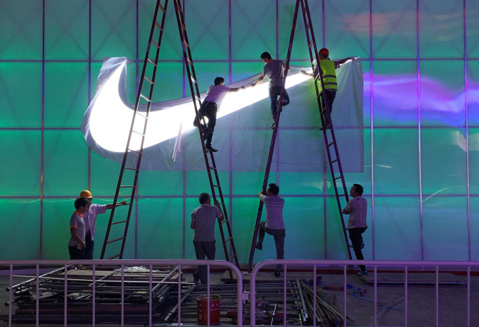 Los trabajadores instalan una lámpara con el logotipo de Nike fuera del Wukesong Arena en Beijing, China, el 28 de agosto de 2019. Foto tomada el 28 de agosto de 2019. REUTERS/Tingshu Wang