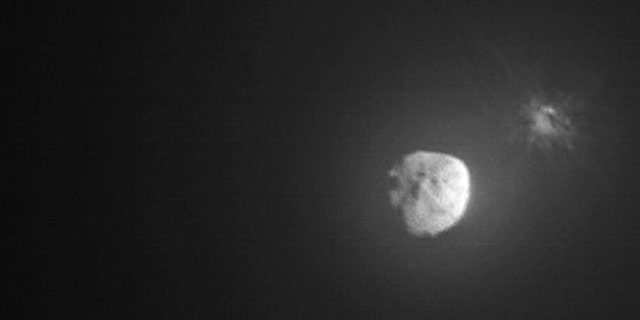 En esta imagen proporcionada por la NASA, los escombros son expulsados ​​del asteroide Demorphos, a la derecha, unos minutos después de la colisión deliberada de la misión Prueba de redirección de asteroides duales (DART) de la NASA el 26 de septiembre de 2022, capturada por la cercana agencia espacial italiana LICIACube.  El martes 5 de octubre de 2022, la NASA dijo que la nave espacial había cambiado con éxito su órbita. 