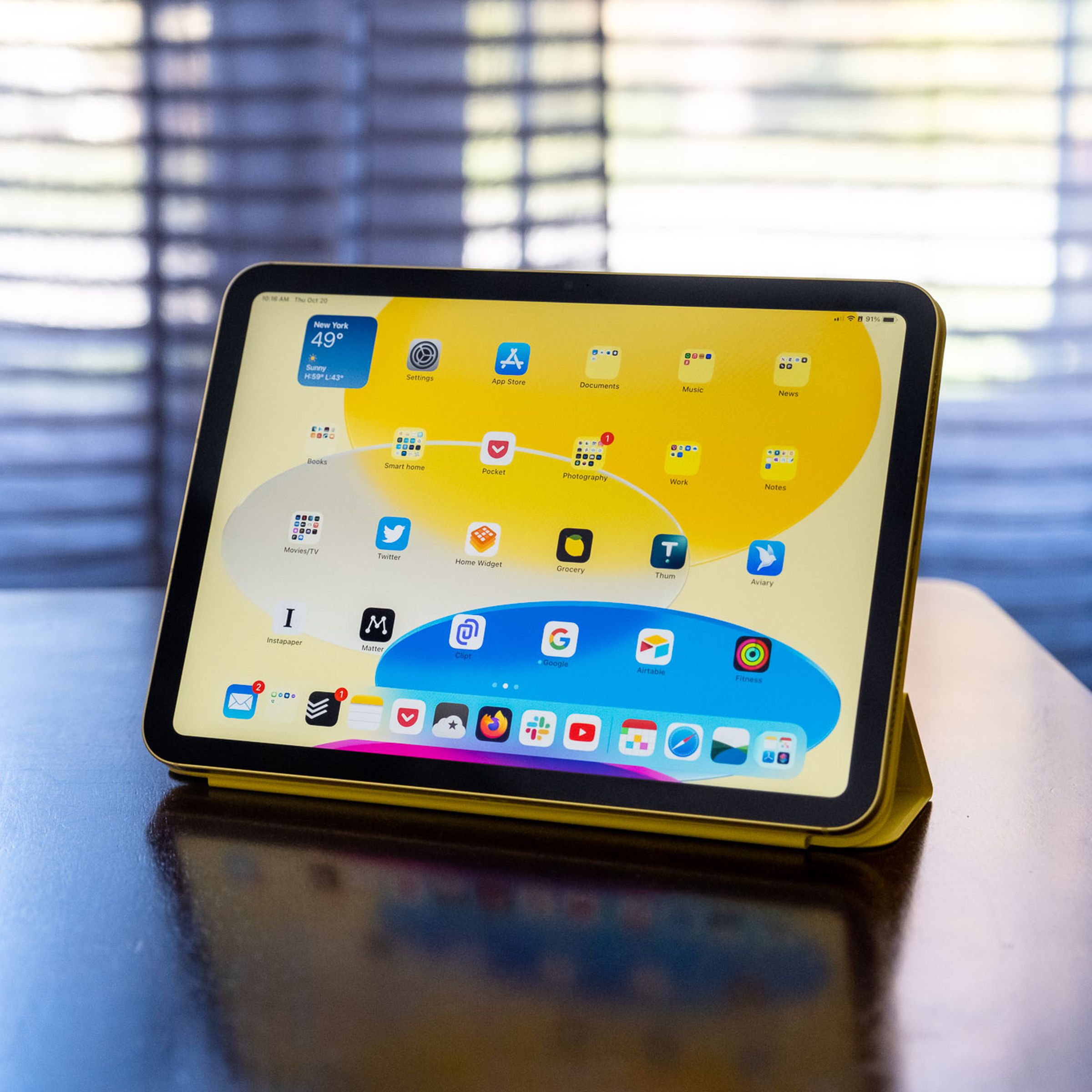 Un iPad de décima generación en un Apple Smart Folio sobre una mesa de madera.